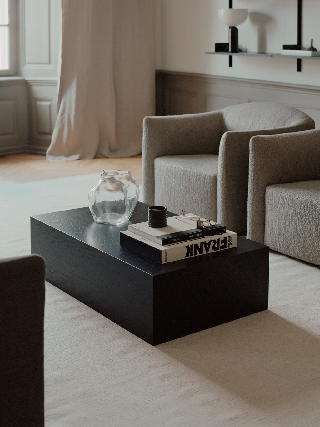 New Works Mass Coffee Table w. Drawer, a striking matte black rectangular coffee table crafted from dark-stained solid wood with a visible grain texture and a low-profile, blocky silhouette. This modern minimalist coffee table features integrated storage with its hidden drawer, embodying a contemporary or brutalist design aesthetic. Ideal for sophisticated living rooms, minimalist interiors, or as a bold statement piece in a Scandinavian-inspired lounge.