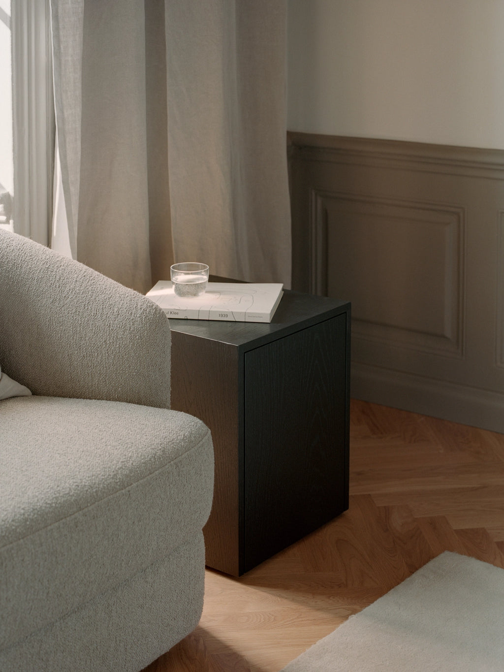 New Works Mass Side Table w. Drawer, a minimalist cube-shaped dark stained oak side table with a visible wood grain texture and clean, contemporary lines. This sleek furniture piece features an integrated storage drawer, making it ideal as a modern bedside table for Scandinavian bedrooms or a stylish end table for minimalist living rooms.
