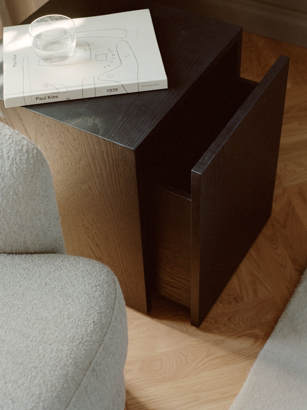 New Works Mass Side Table w. Drawer, a striking dark stained oak veneer side table with a bold, geometric form and minimalist aesthetic. This contemporary accent table features a unique integrated drawer for discreet storage, showcasing the rich texture of the dark wood grain. Ideal as a modern living room side table or Scandinavian bedside table for design-forward spaces.