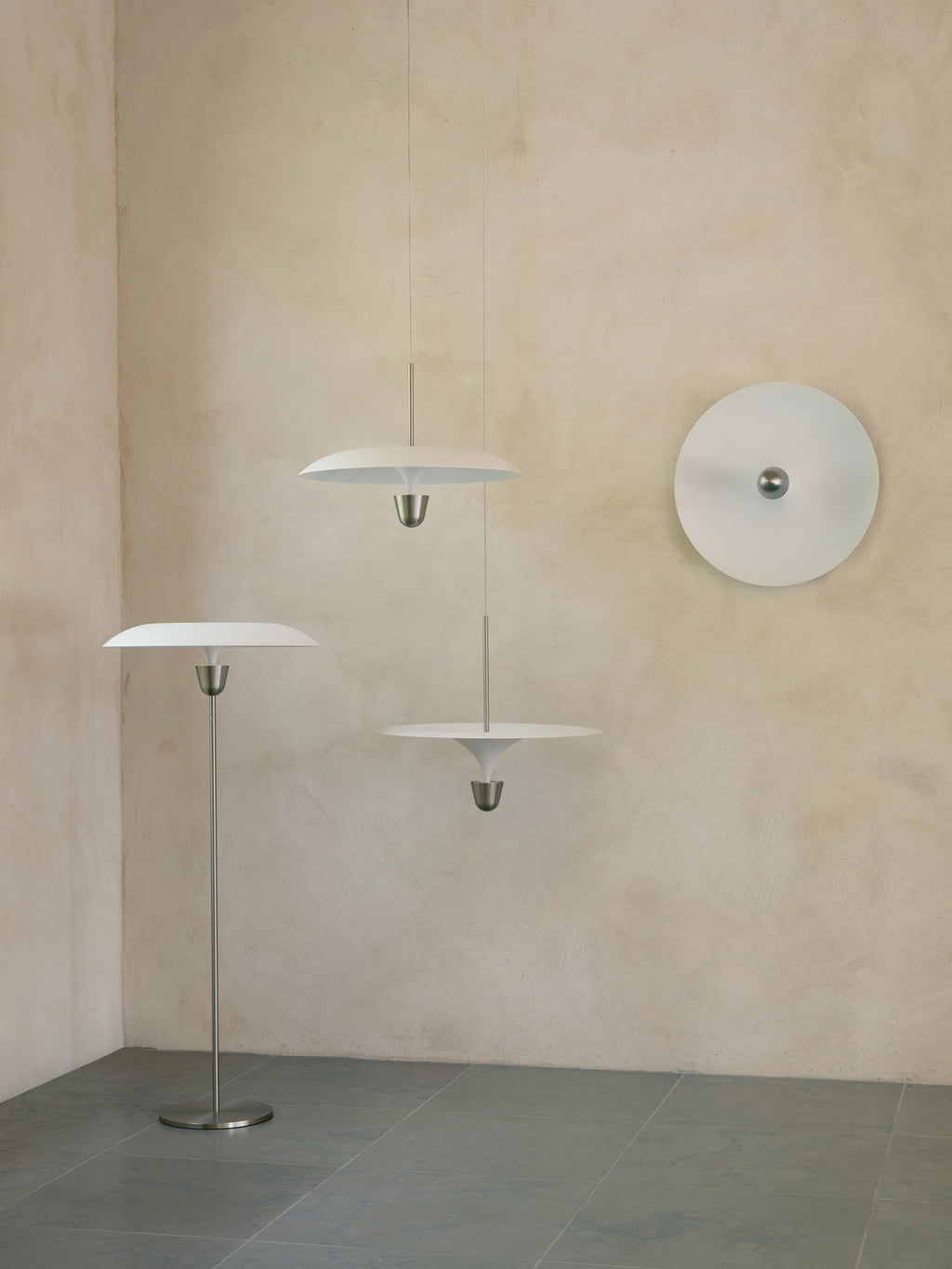 New Works Kantarell Wall & Ceiling Lamp, a modern minimalist matte white metal circular lamp with a central brushed stainless steel accent, offering sleek, diffused lighting. This versatile Scandinavian design is perfect as a contemporary wall sconce for living rooms or an elegant ceiling lamp for bedrooms and hallways.