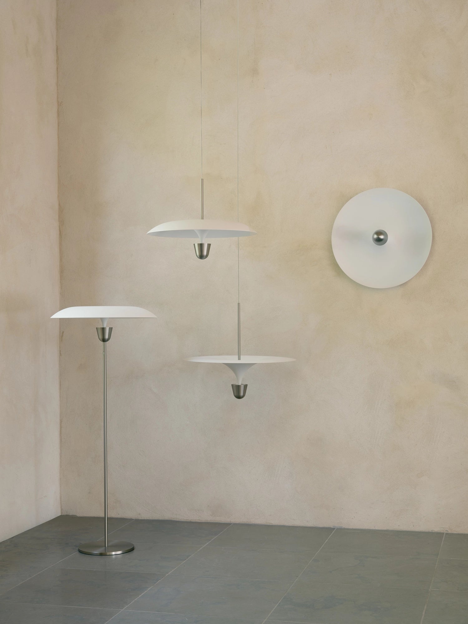 New Works Kantarell Wall & Ceiling Lamp, a modern minimalist matte white metal circular lamp with a central brushed stainless steel accent, offering sleek, diffused lighting. This versatile Scandinavian design is perfect as a contemporary wall sconce for living rooms or an elegant ceiling lamp for bedrooms and hallways.