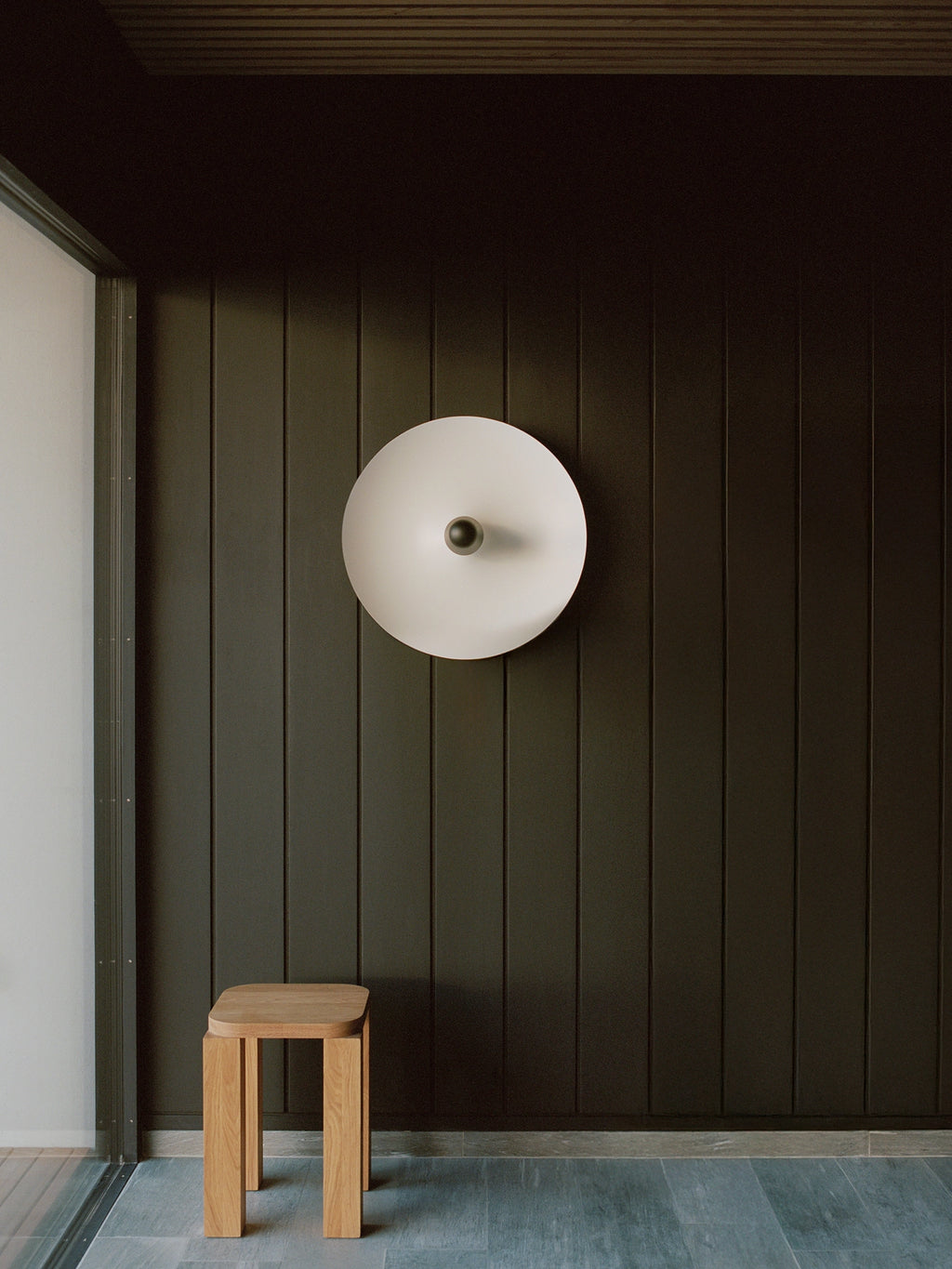 New Works Kantarell Wall & Ceiling Lamp, a modern minimalist light fixture featuring a large circular matte white aluminum reflector with a contrasting matte black metal stem.