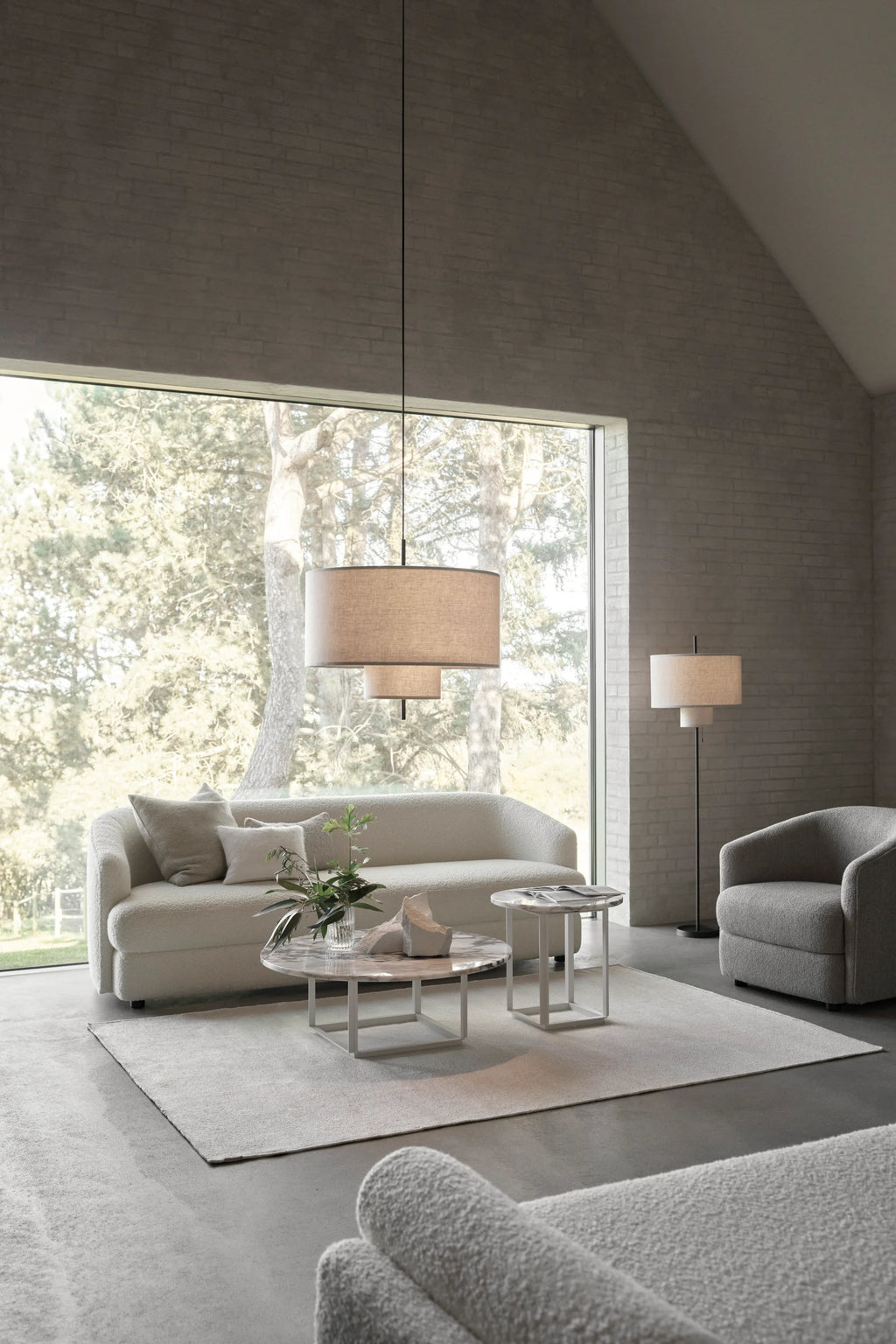 New Works Florence Side Table, a round white Italian marble tabletop with delicate grey veining and a polished finish, supported by a minimalist matte white metal frame base with clean, geometric lines. This contemporary side table is ideal for adding an organic modern touch to living rooms, bedrooms, or sophisticated office spaces.