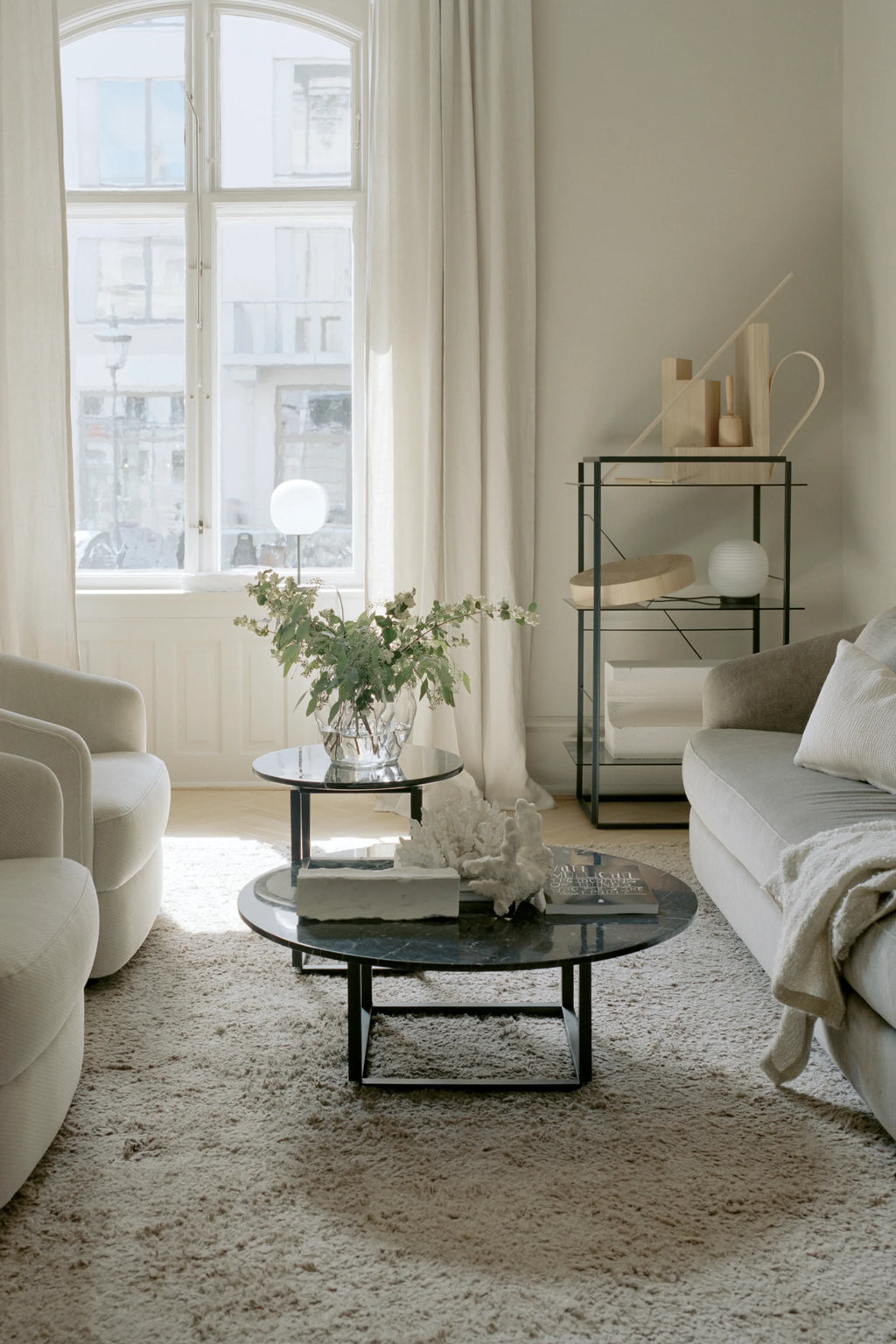 New Works Florence Side Table, a modern minimalist side table featuring a luxurious black marble round tabletop with subtle white veining, set atop a sleek matte black metal base with clean lines. This elegant contemporary end table is perfect for sophisticated living rooms, stylish bedrooms, or as an accent piece in a refined home office.