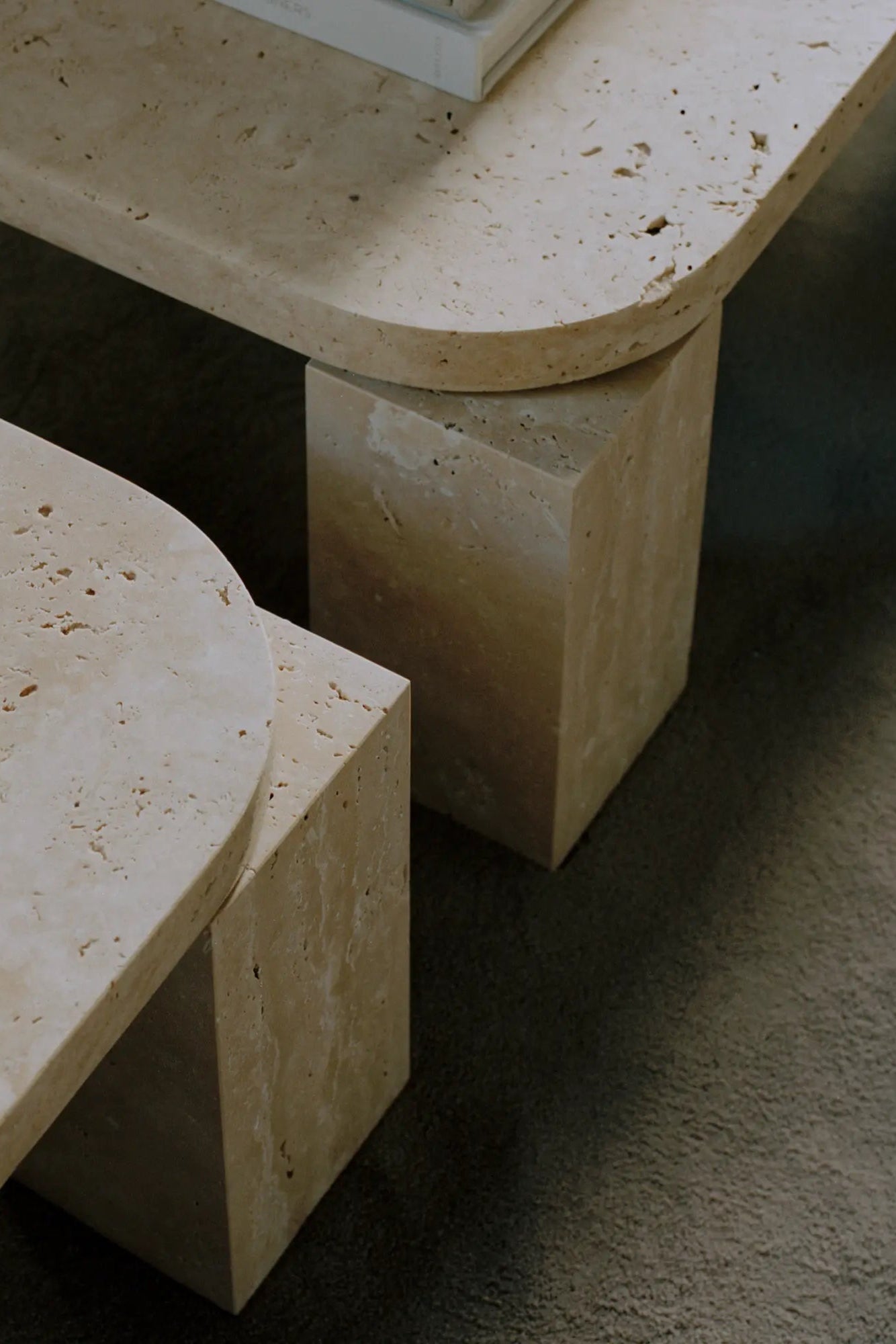Square travertine coffee table with metal legs in natural light