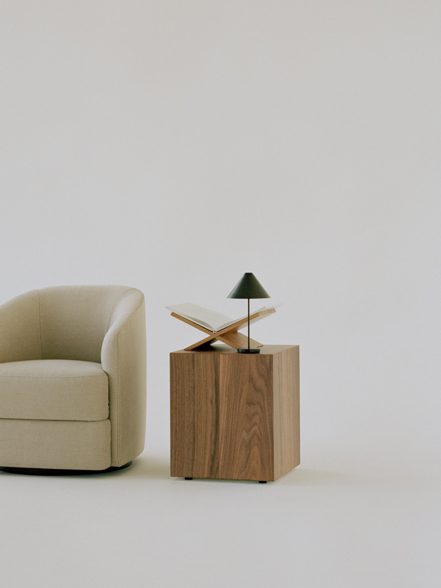 New Works Mass Side Table, a modern minimalist cube side table crafted from rich dark walnut solid wood with a smooth, visible grain and a sturdy, block-like silhouette. This contemporary accent table offers a sophisticated surface for living room decor or as a chic bedside table in organic modern and Scandinavian interiors.