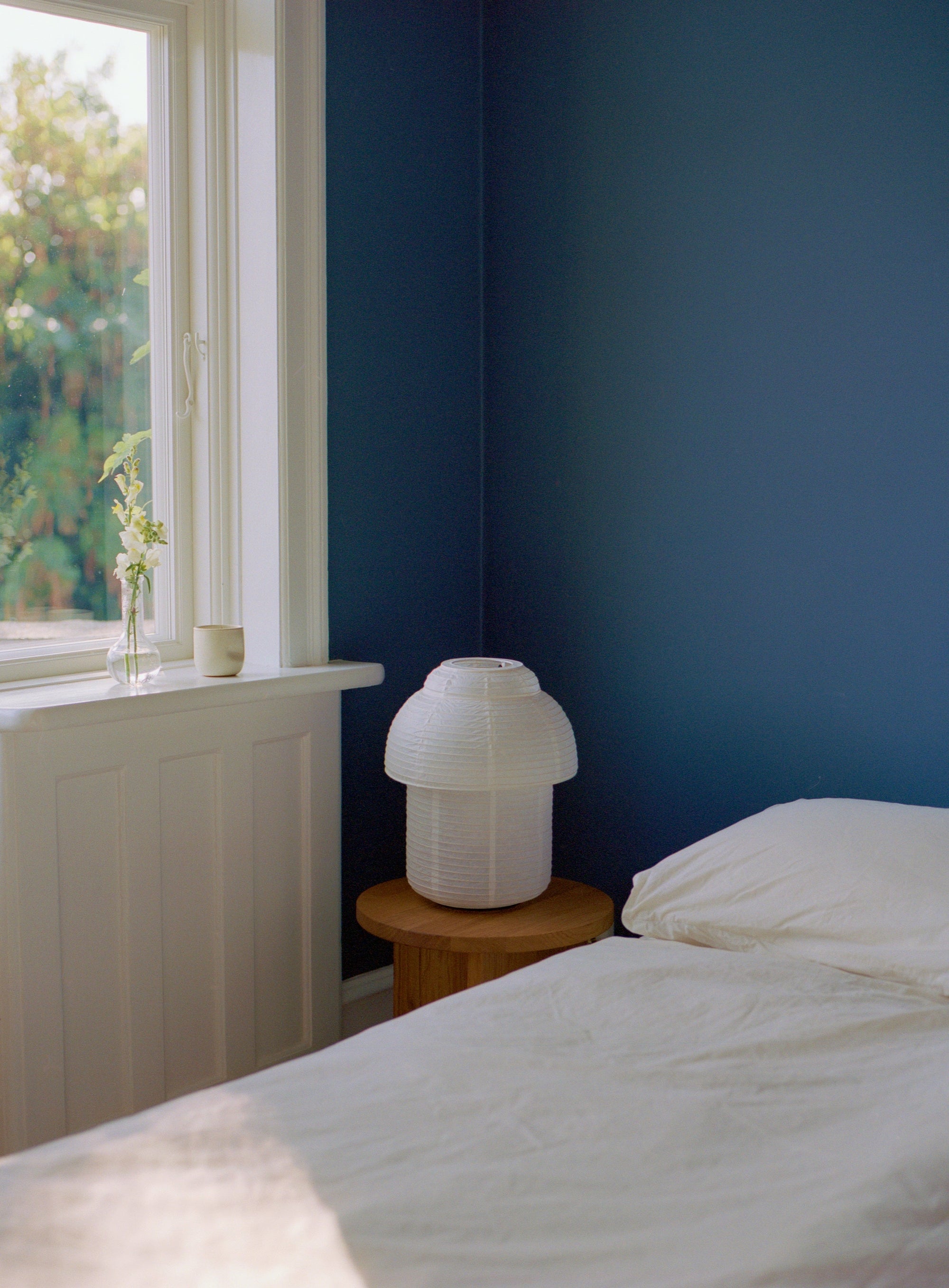 Made by Hand Papier Double Ø30 Table Lamp, a minimalist white pleated paper table lamp featuring an organic mushroom-like silhouette and ribbed texture, embodying a contemporary Scandinavian or Japandi design aesthetic. This elegant paper lamp provides soft, ambient lighting, perfect as a bedside lamp for a serene bedroom, cozy reading nook, or stylish living room accent.