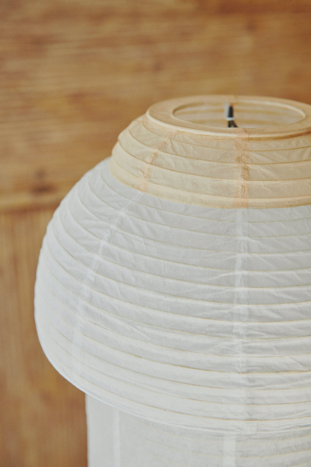 Made by Hand Papier Double Ø30 Table Lamp, a Japandi-inspired organic modern table lamp featuring a handcrafted cream-colored pleated rice paper shade with horizontal ribs and a natural light wood-toned paper ring. This minimalist paper lantern lamp is perfect for creating soft ambient lighting in Scandinavian living rooms, serene bedrooms, or for elegant shelf styling.