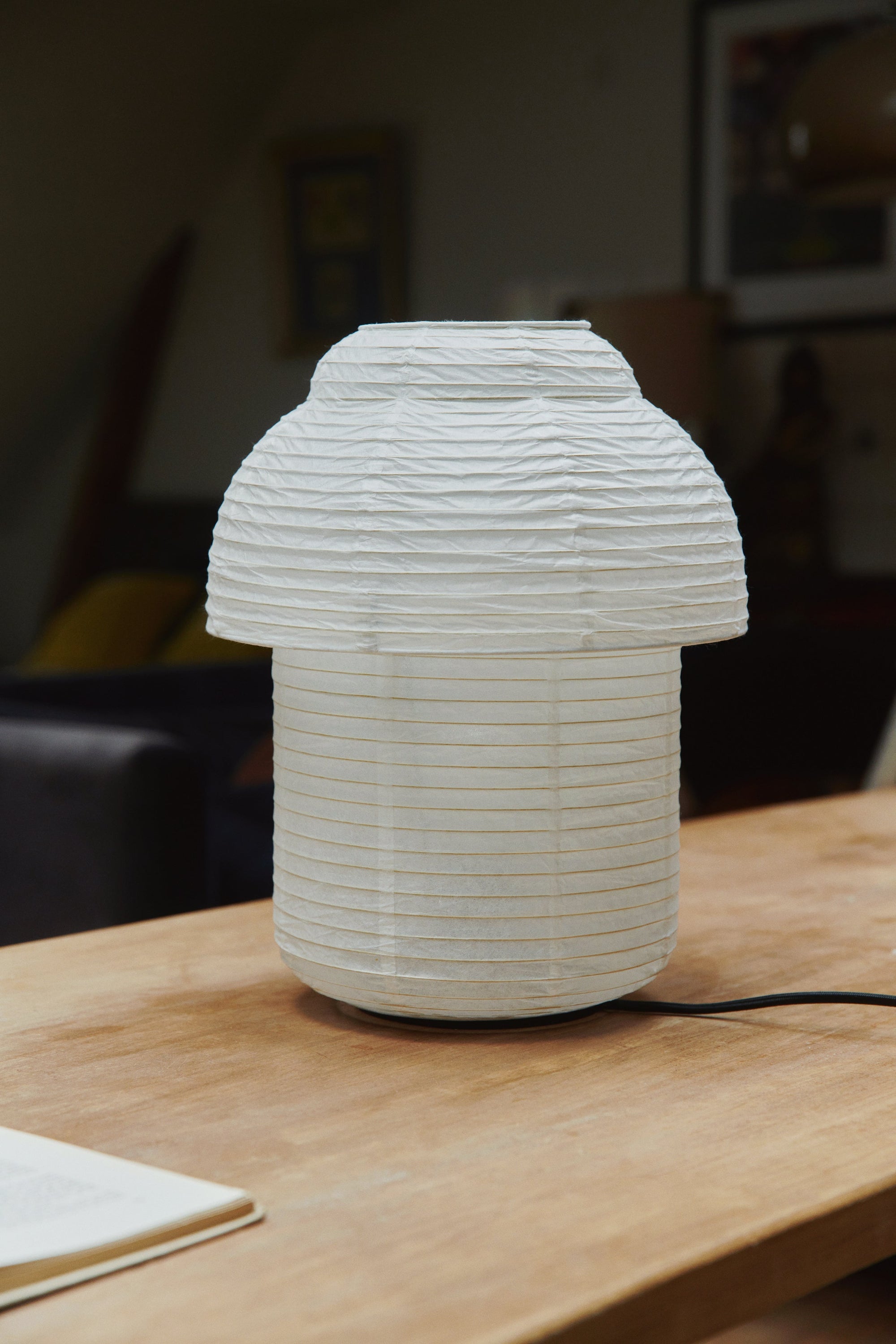 Made by Hand Papier Double Ø30 Table Lamp, a cream-colored table lamp featuring a distinctive mushroom-like, tiered shade crafted from delicate pleated washi paper, providing soft, diffused ambient light. This elegant paper lamp is perfect for Japandi, Scandinavian, or organic modern interiors, ideal as a bedside table lamp or living room accent.