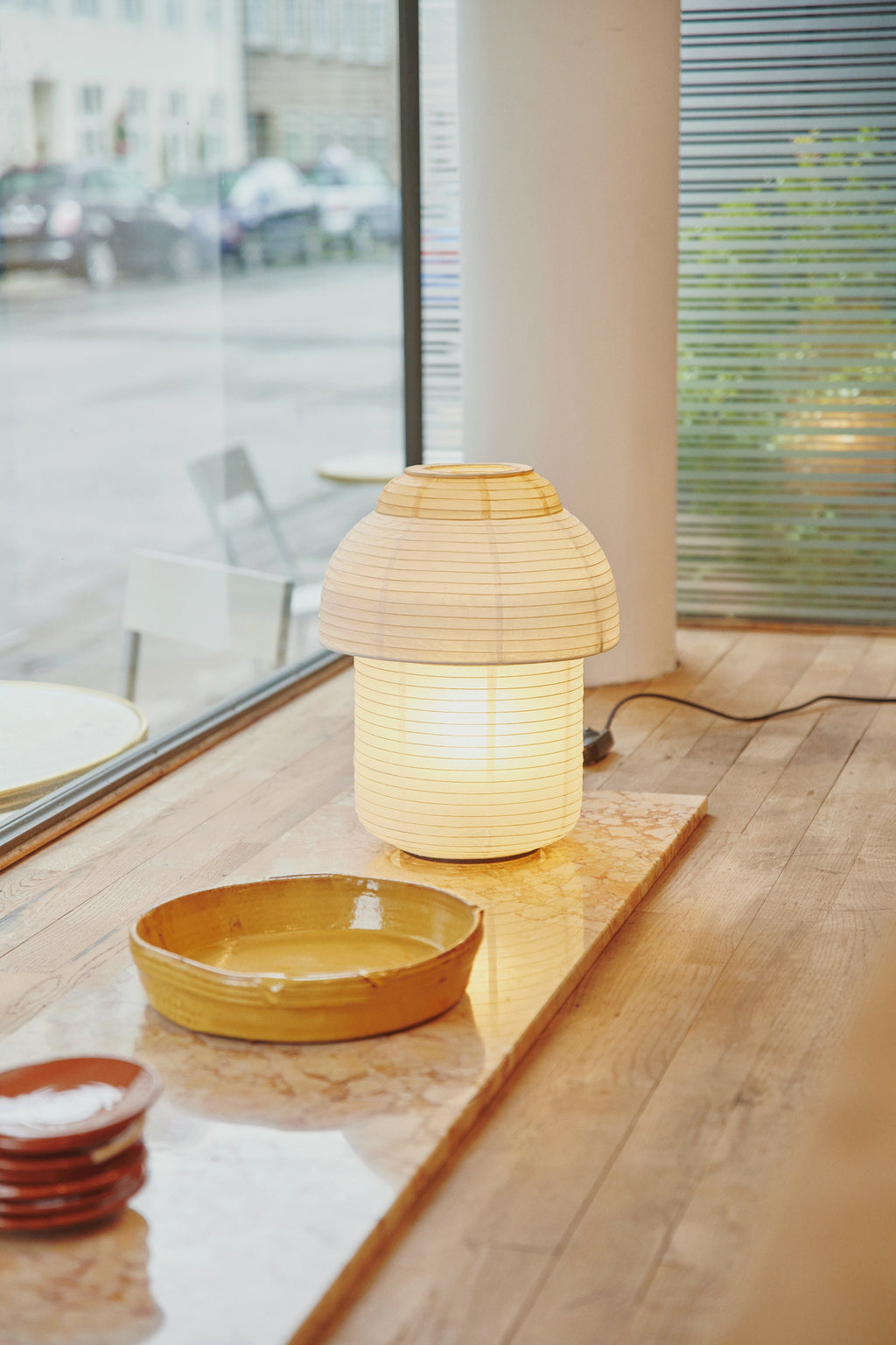 Made by Hand Papier Double Ø30 Table Lamp, a cream-colored japandi table lamp featuring a distinctive double-tiered mushroom-shaped shade crafted from translucent ribbed natural paper, emitting a soft,.
