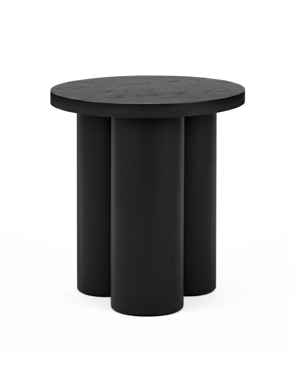 noo.ma Oly Stool, a modern minimalist stool and versatile accent table crafted from solid wood with a matte black finish, featuring a round top and three chunky cylindrical legs. Its sculptural form and dark aesthetic make it ideal as a contemporary side table or brutalist-inspired bedside table for living rooms and bedrooms.