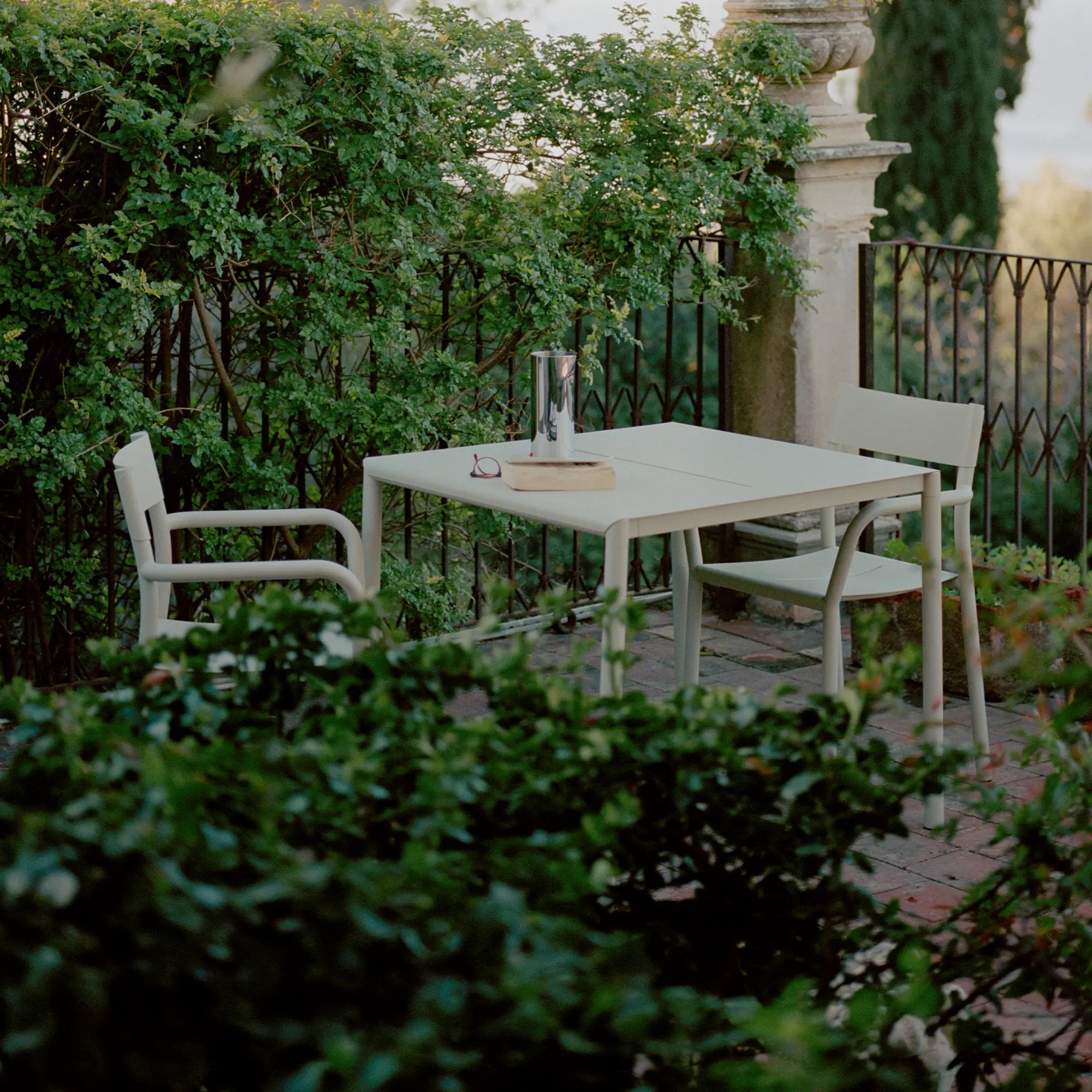  Group of people sitting around the outdoor may table in a backyard setting