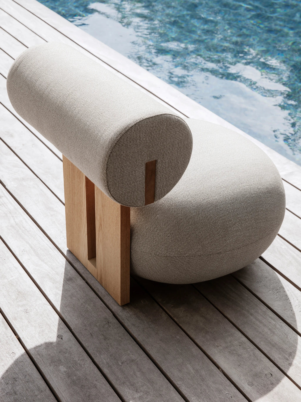 NORR11 Outdoor Hippo Lounge Chair, an organic modern outdoor lounge chair featuring a light beige textured bouclé-style fabric upholstery with a distinctive cylindrical backrest and spherical seat, supported by a minimalist.