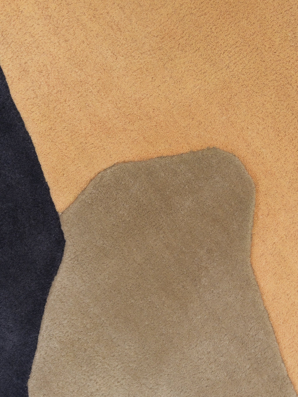 Haus Üger Papillon Rug, a hand-tufted wool area rug featuring a plush textured pile and an organic abstract design with soft, curvilinear color blocks in charcoal grey, warm sand, and.