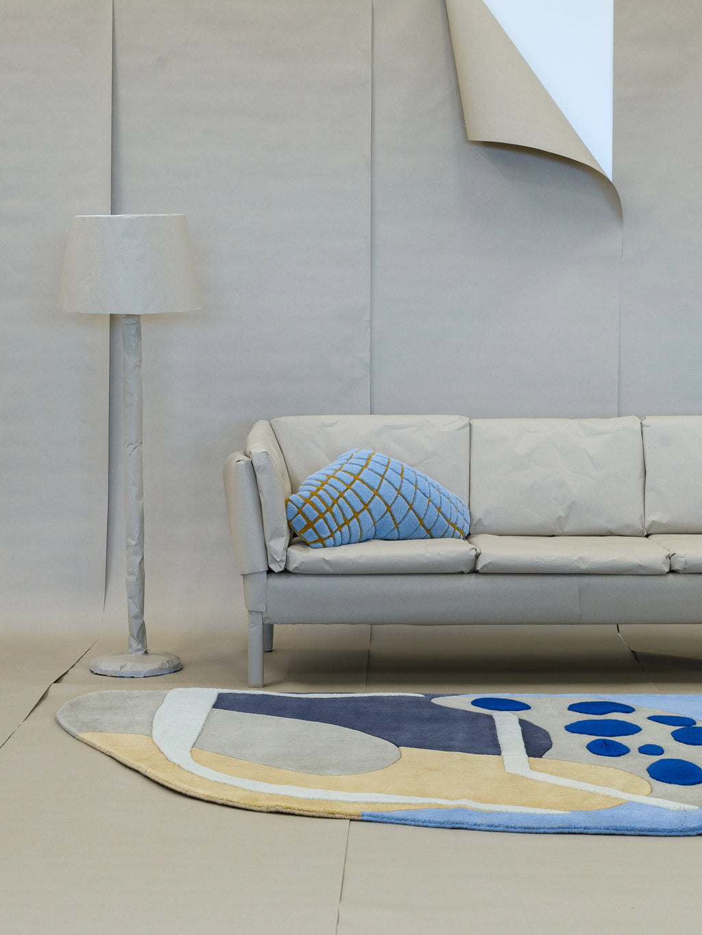 Haus Üger Papillon Rug, a vibrant hand-tufted wool area rug featuring a playful abstract design with an organic, irregular shape and varied pile height. It showcases a contemporary color palette of deep navy, sky blue, soft yellow, light grey, and cream, accented by raised bright blue circles. Ideal as a statement piece for modern living rooms, playful bedrooms, or creative contemporary interiors.