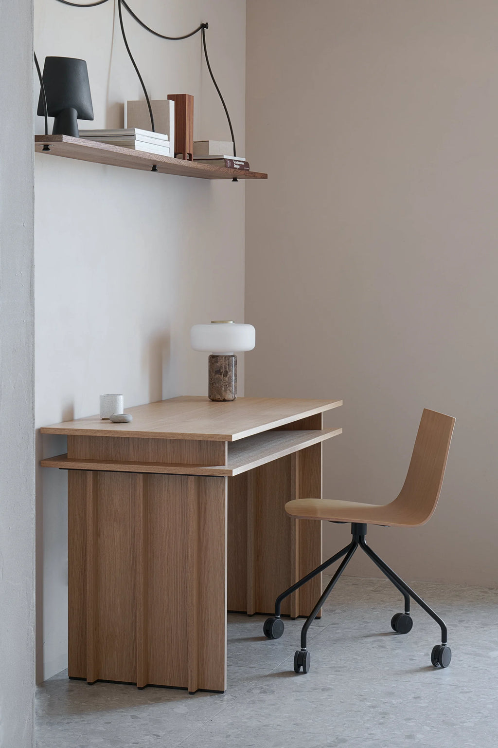 TAMO Piato Desk, a premium light oak wood desk with a floating top and fluted panel sides beside a wooden office chair, in a modern home office setting. Ideal for stylish workspaces.