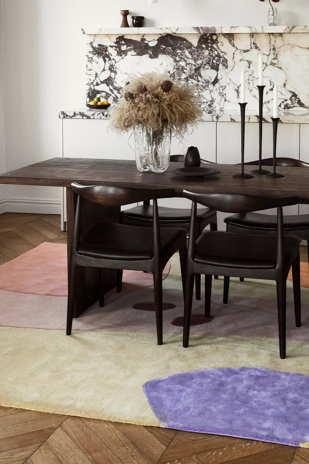 Layered Magical Garden Wool Rug, a plush, colorful area rug with organic shapes in pastel pink, yellow, and purple hues. Perfect for adding a soft, artistic touch to modern living spaces.
