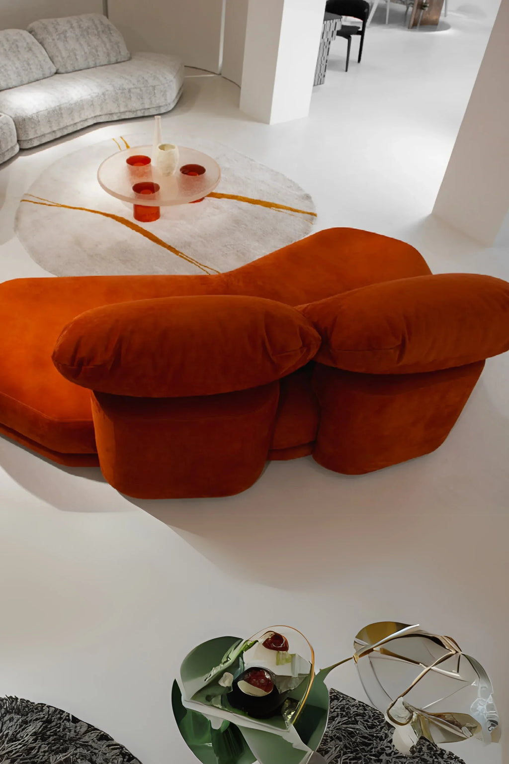 Hessentia Cliff Sofa, a striking organic modern sofa upholstered in a rich burnt orange velvet-like fabric, featuring an invitingly plush texture and a unique sculptural form with oversized, rounded cushions. This contemporary designer sofa is perfect as a statement piece for luxury living rooms and maximalist interiors, offering exceptional comfort and bold style.