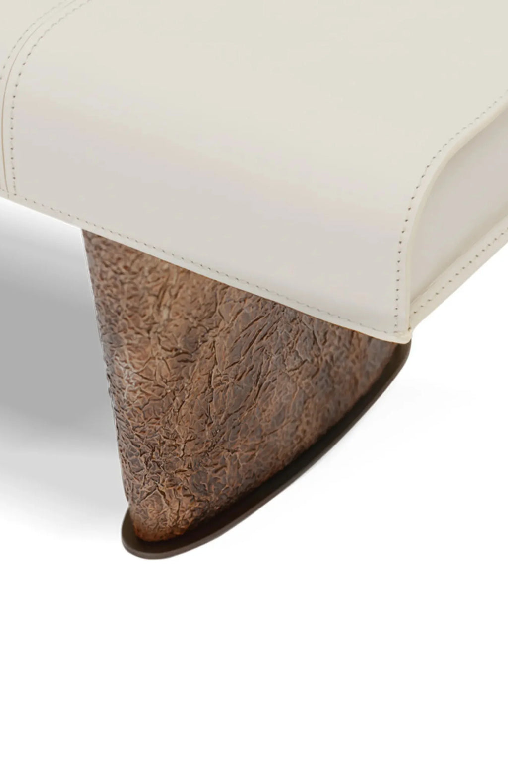 Hessentia Cheope Bench, a luxurious contemporary accent bench featuring a smooth cream leather upholstered top with precise stitching, resting on a dramatic sculptural base crafted from richly textured, distressed dark bronze-effect metal.
