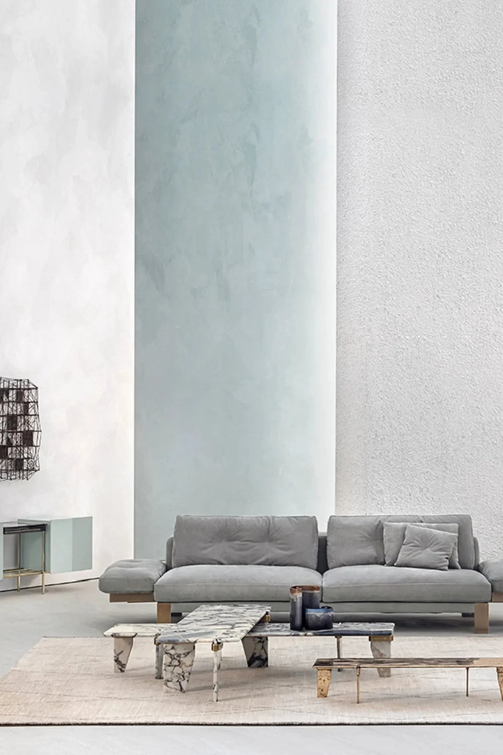 Hessentia Levante Sofa, a contemporary modular sofa featuring plush light grey fabric upholstery with deep button tufting on the back cushions, set upon a distinctive low-profile natural wood platform base. This organic modern design offers deep seating and wide, relaxed armrests, making it perfect for a spacious living room or modern minimalist interior.