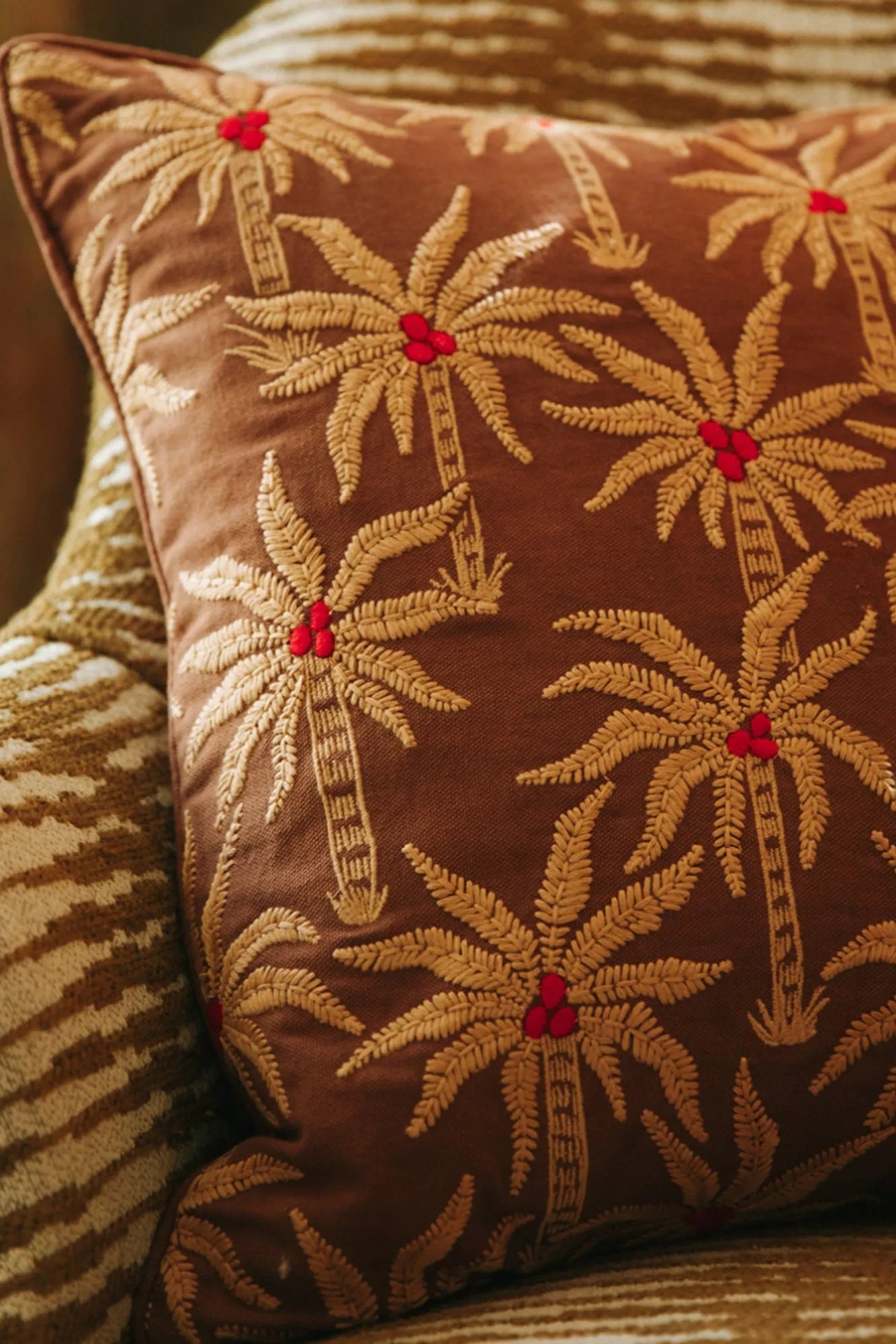  A pair of Laura Cushions in rich jewel tones adding a pop of color to a neutral sofa