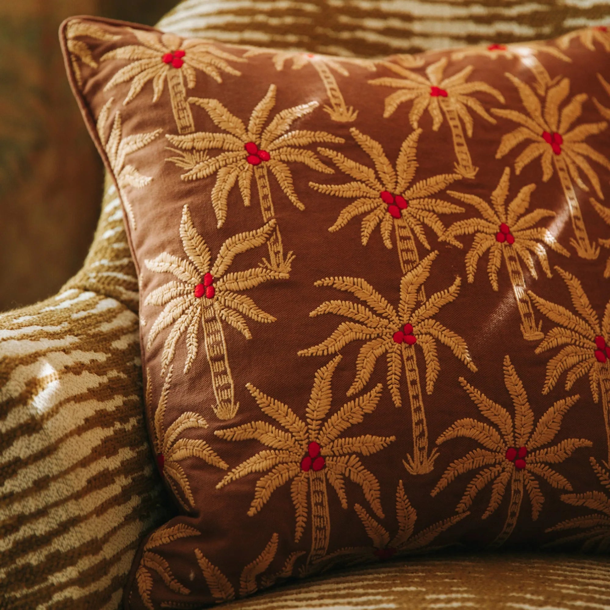  A pair of Laura Cushions in rich jewel tones adding a pop of color to a neutral sofa