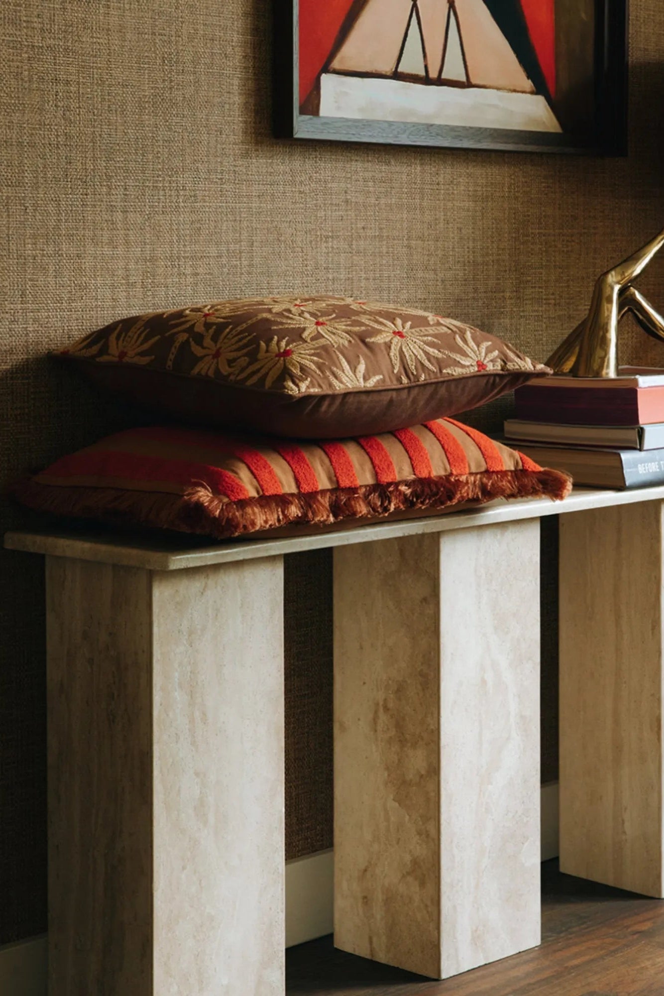  A top view of a Laura Cushion styled on a bed with layered textiles