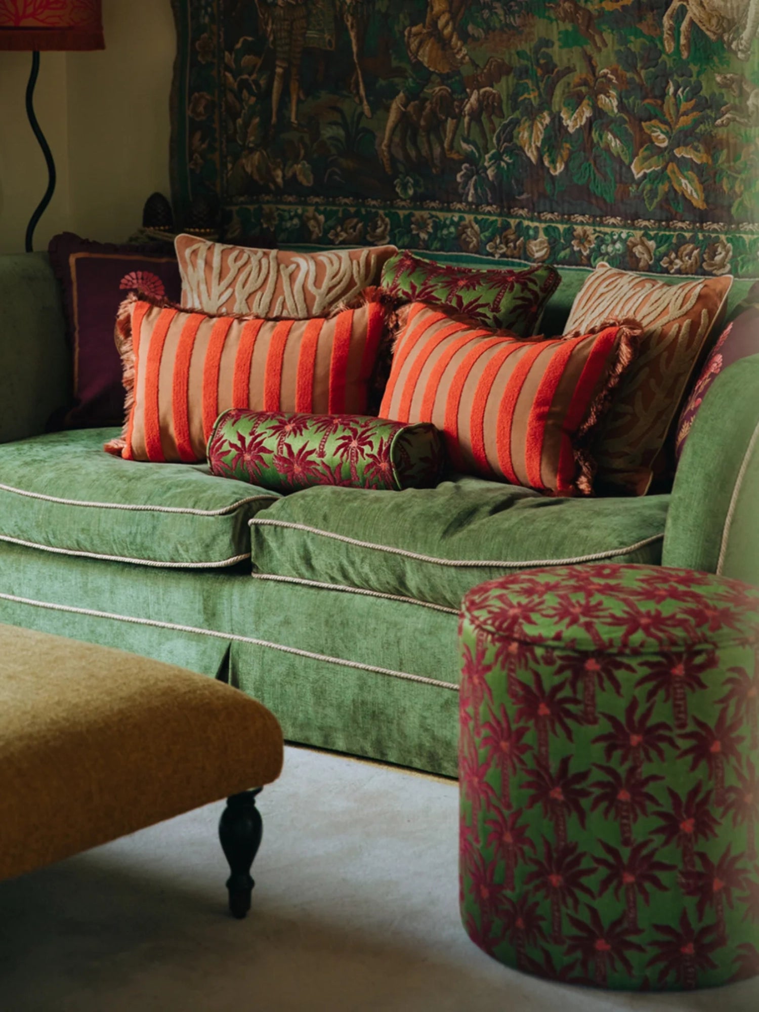 Palais Jackie Throw Pillow, a vibrant maximalist accent cushion featuring bold orange vertical stripes on a warm beige background, crafted from a textured woven fabric and finished with playful matching orange fringe details.