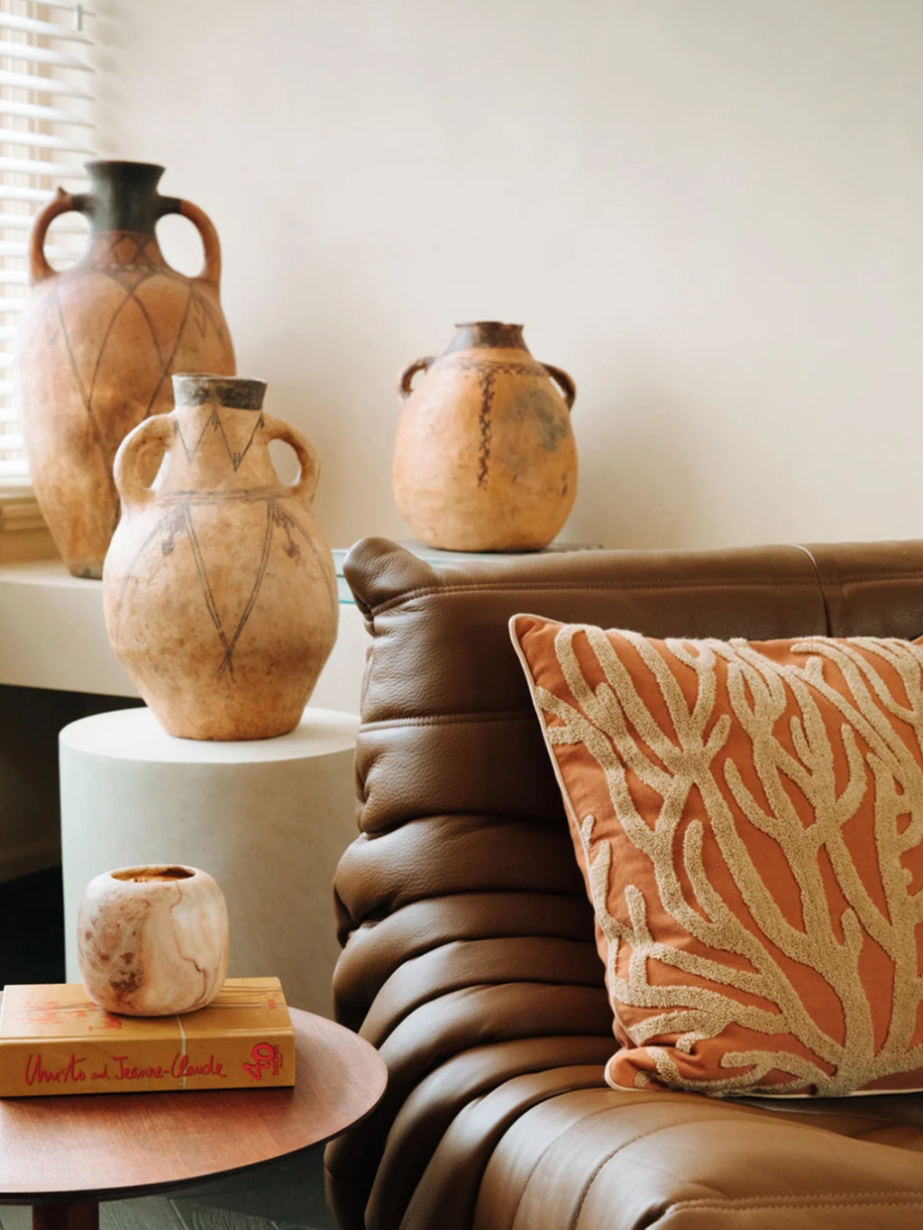 Palais Lauren Throw Pillow, a rectangular rust orange fabric decorative cushion featuring an intricately embroidered organic coral or branch-like pattern in a natural beige tone, creating a rich textured surface.