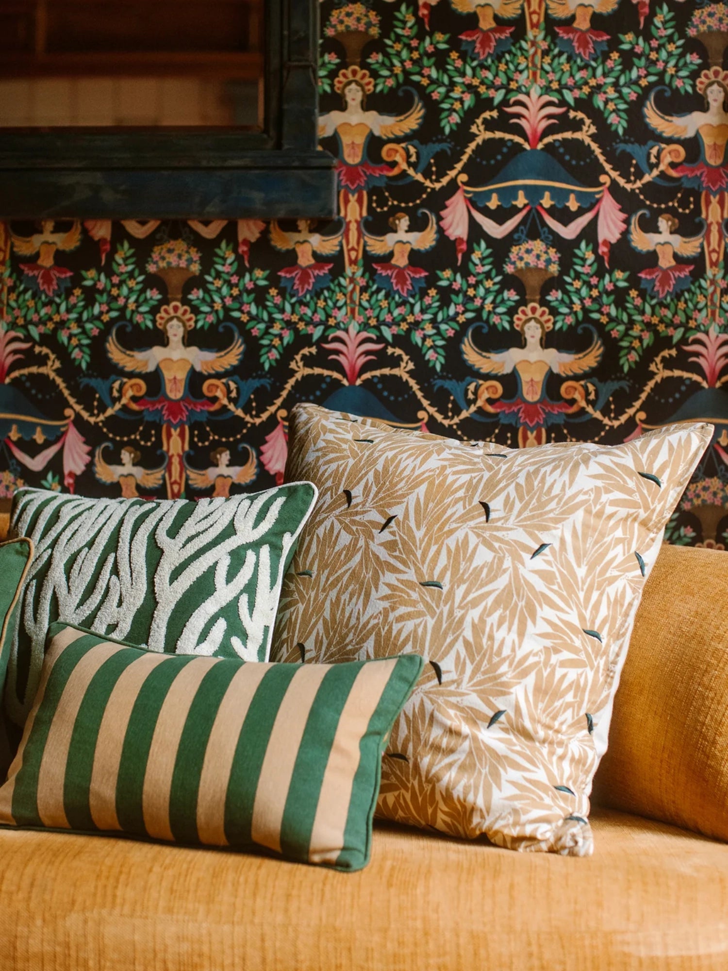 Palais Lauren Throw Pillow, a square decorative cushion featuring a golden-tan botanical leaf print against a crisp white background, accented with small dark blue bird-like shapes. This soft fabric printed pillow offers an organic modern and boho aesthetic, perfect for adding warmth and texture to a living room sofa or bedroom accent chair in an eclectic maximalist interior.