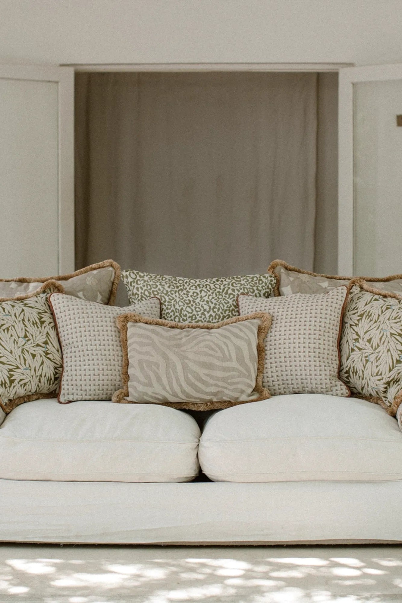 Amina Cushion with Frills shown in a decorative arrangement, enhancing the visual appeal of the room 