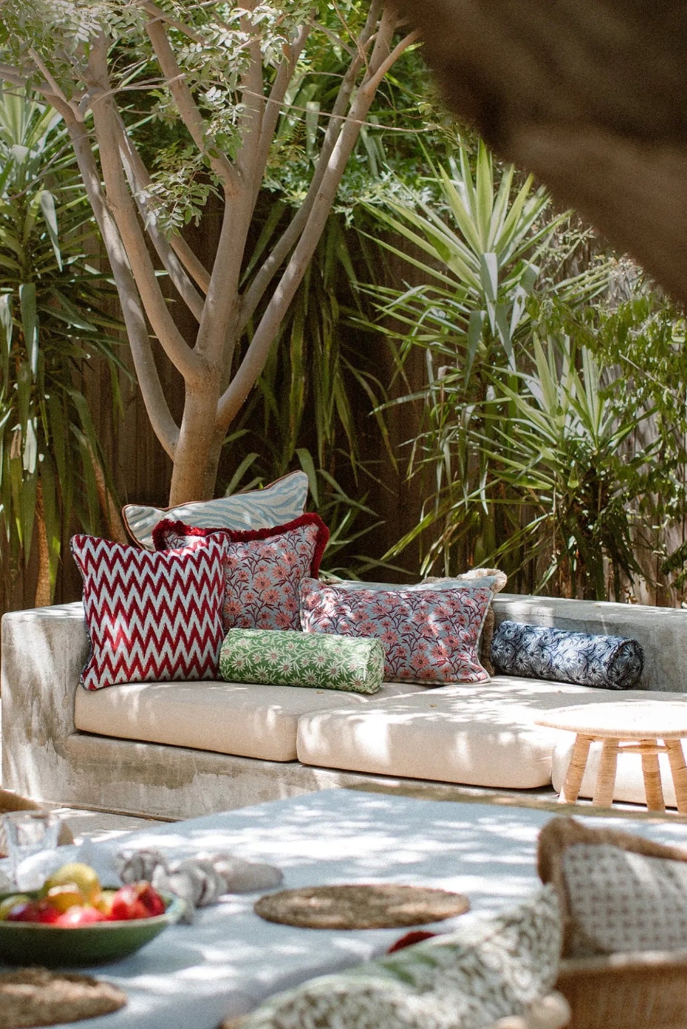 Palais Mako Bolster Pillow, a decorative cylindrical cushion available in charming green or deep blue with delicate white floral patterns, crafted from soft, printed fabric.