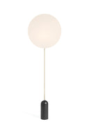 Floor lamp with a round white shade and black base on a white background