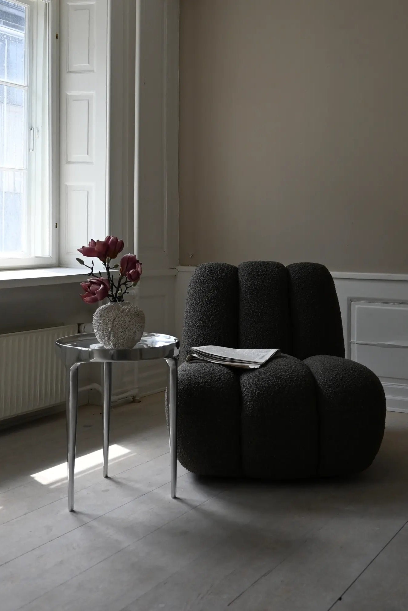 Comfortable and stylish grey fabric toe lounge chair with cushioned seat and wooden legs perfect for relaxing in the living room or home office