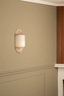 Wall sconce on a beige wall with wooden trim