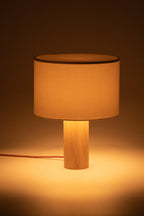 Table lamp with wooden base and beige fabric shade on a dark background