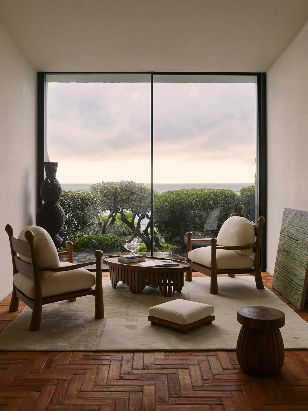 Heaps & Woods Pitufi Lounge Chair, a robust organic modern lounge chair featuring a solid natural wood frame with chunky, rounded legs and armrests, supporting plush cream-colored upholstered cushions.