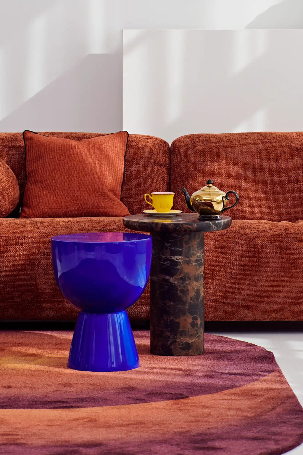 POLSPOTTEN Tip Tap Stool, a vibrant electric blue high-gloss lacquered fiberglass stool with a striking sculptural hourglass silhouette, featuring a wide bowl-shaped top and a tapered base. This bold contemporary accent piece offers a reflective, smooth texture and a playful pop art aesthetic. Perfect as a statement side table in modern living rooms, a colorful bedroom accent, or a unique design stool for creative spaces.