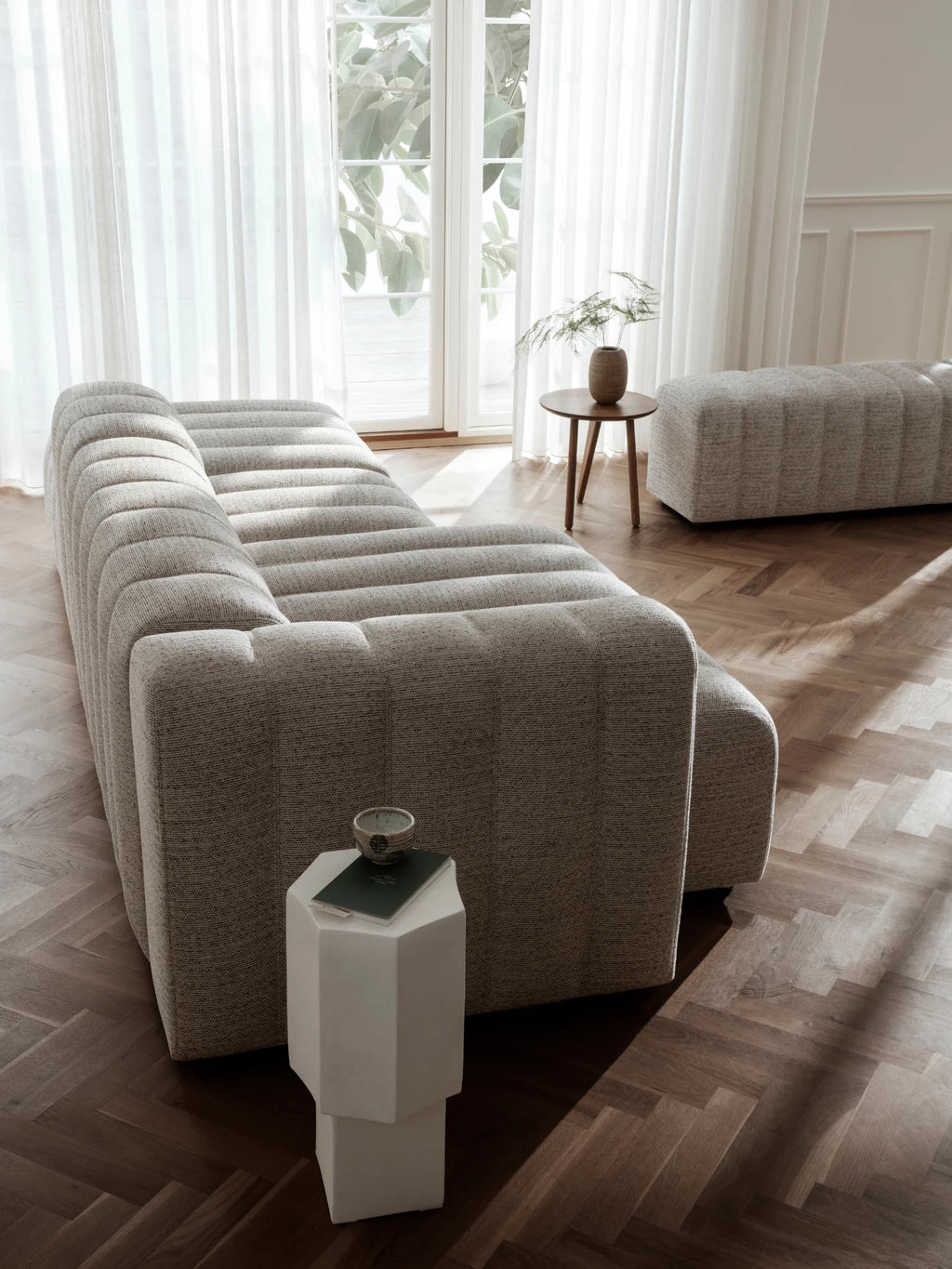 NORR11 Quartz Side Table, a modern sculptural white faceted side table made from durable quartz. This piece adds an elegant accent next to a sofa or armchair.