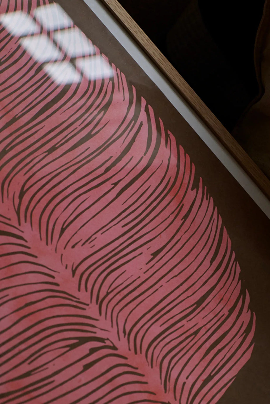 The Poster Club Pink Lagoon, an abstract art print featuring organic dark brown wavy lines against a muted rose pink background, framed in a light natural oak frame with a crisp white mat. This contemporary wall art is ideal for adding a soft, organic modern touch to Scandinavian living rooms, minimalist bedrooms, or boho-inspired gallery walls.