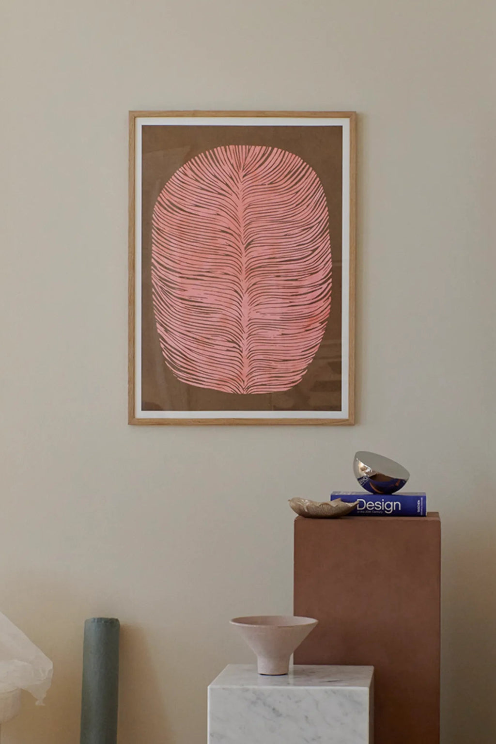 The Poster Club Pink Lagoon, an abstract art print featuring a large organic leaf-like shape with salmon pink textured lines against a deep brown background, framed in a light natural oak frame with a crisp white mat. This contemporary wall art is perfect for modern minimalist or organic modern interiors, enhancing gallery walls and living room decor.