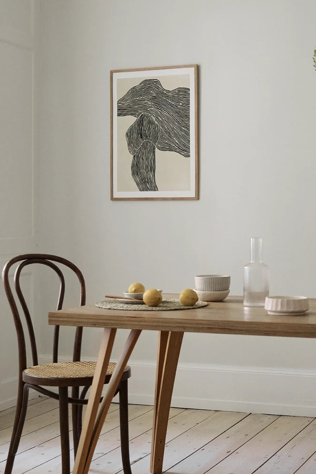 The Poster Club The Line No 16, an abstract art print featuring a complex pattern of black organic lines that create a flowing, textured shape against a light beige background, encased in a simple natural oak frame. This minimalist and contemporary wall art is perfect for Scandinavian dining rooms, modern living spaces, or curated gallery walls.