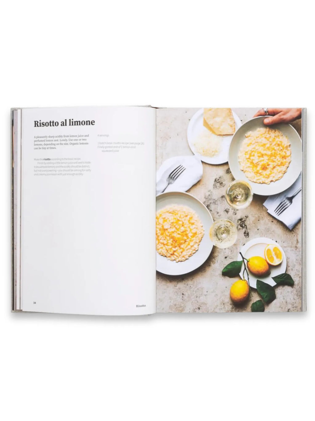 Book Rice and Shine, an open cookbook displaying a "Risotto al limone" recipe with vivid food photography. The right page features two plates of creamy lemon risotto, two wine glasses, whole lemons with green leaves, and grated cheese, all arranged on a light gray marbled surface. This popular cookbook is perfect for home chefs seeking delicious, easy-to-follow Italian recipes.