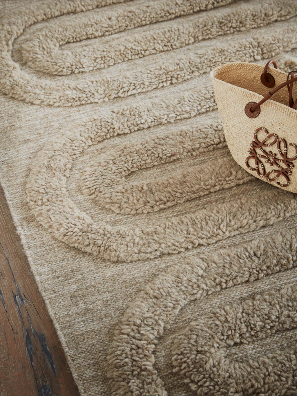 Tinted Objects Riklund Wool Rug, a luxurious beige wool rug with a raised, plush, wavy loop pile pattern on a flat woven base. This hand-tufted accent floor covering adds warmth and texture to any living space, perfect for contemporary home decor enthusiasts seeking comfort and style.