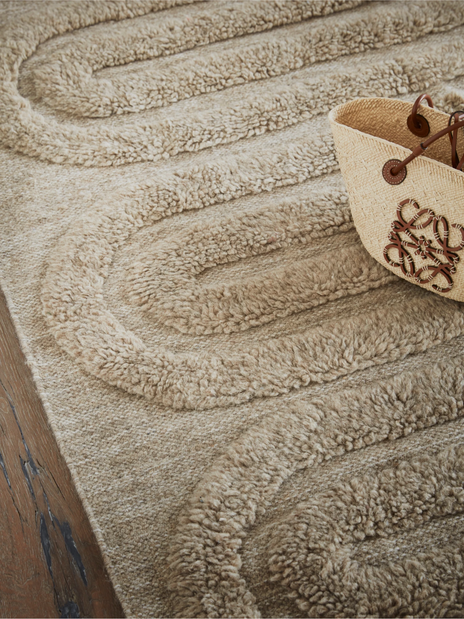 Tinted Objects Riklund Wool Rug, a luxurious beige wool rug with a raised, plush, wavy loop pile pattern on a flat woven base. This hand-tufted accent floor covering adds warmth and texture to any living space, perfect for contemporary home decor enthusiasts seeking comfort and style.