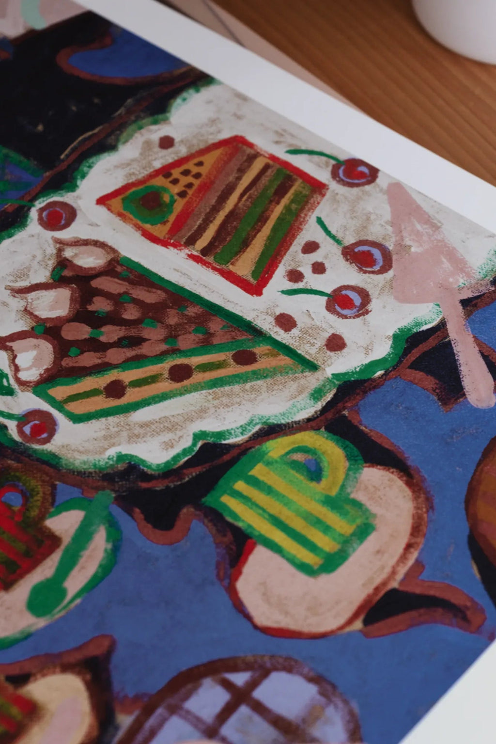 The Poster Club Cake, a vibrant naive art print featuring abstract cake slices and desserts in a playful, colorful composition with a dominant royal blue background. This graphic poster showcases bold brushstrokes in brown, white, red, green, and yellow, evoking a charming, childlike aesthetic. Ideal as cheerful wall art for kitchen decor, dining rooms, or a playful touch in modern living spaces.