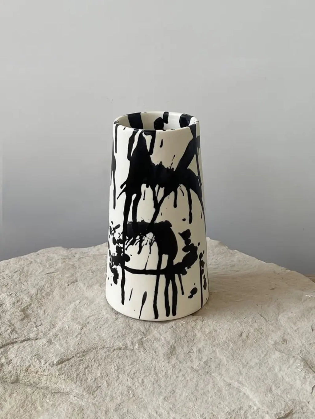 OWO Ceramics x That Cool Living Rock Vase II, a handcrafted ceramic vase featuring a striking cream glaze with bold black drips. This modern, elegant piece adds artistic flair. Ideal for art lovers and design enthusiasts looking for a unique statement piece.