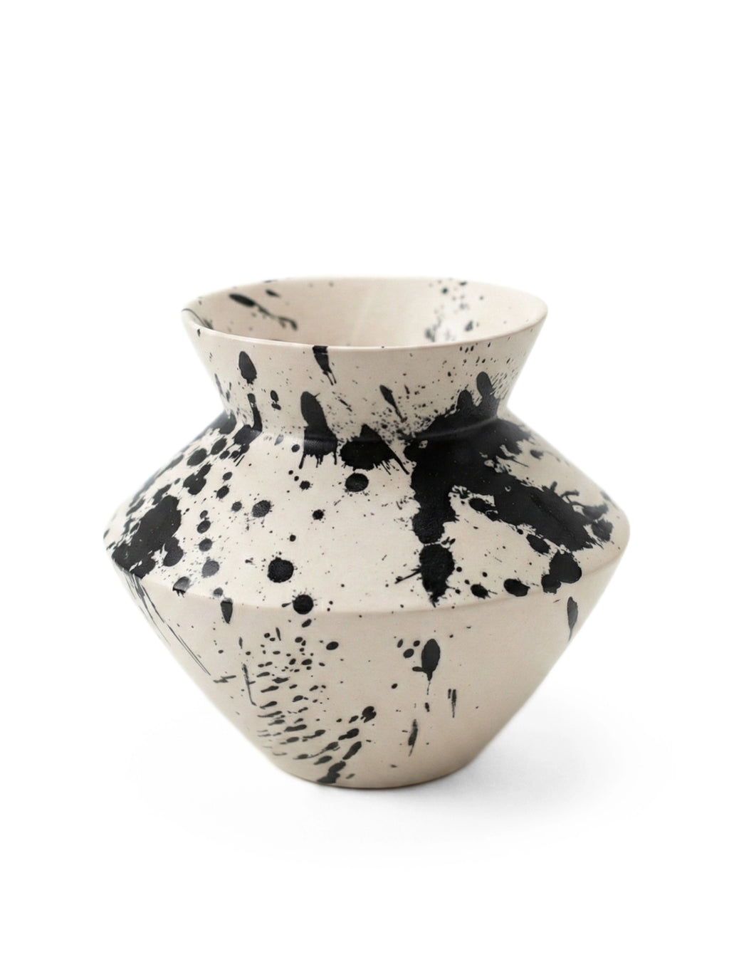 OWO Ceramics x That Cool Living Rock Vase I, a stylish, handcrafted ceramic vase in a neutral cream hue with bold, modern black splatter paint accents. Its distinctive geometric shape makes it a perfect centerpiece for a contemporary home. This durable, elegant vase is ideal for discerning decorators seeking unique, artistic flair for their living spaces.