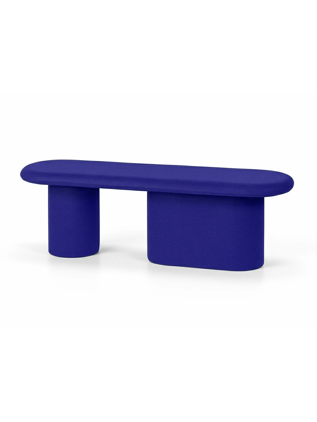 noo.ma Rull Bench, a vibrant royal blue upholstered bench with a striking sculptural and organic modern design, featuring a long, rounded oval top and two distinctive, softly shaped legs: one cylindrical and one rectangular. This bold minimalist seating piece offers a playful accent for contemporary living rooms, entryways, or design-forward bedrooms.