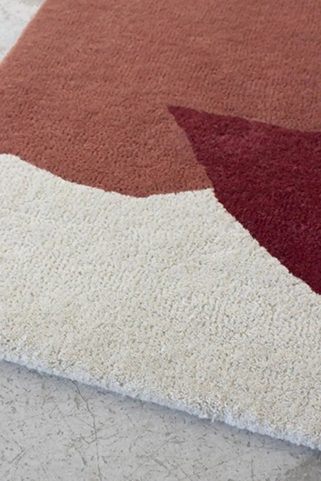 Layered Cloudberry Wool Rug, an abstract modern area rug featuring a plush pile in off-white, warm terracotta, and deep burgundy tones. Perfect for adding a soft, contemporary focal point to any li...